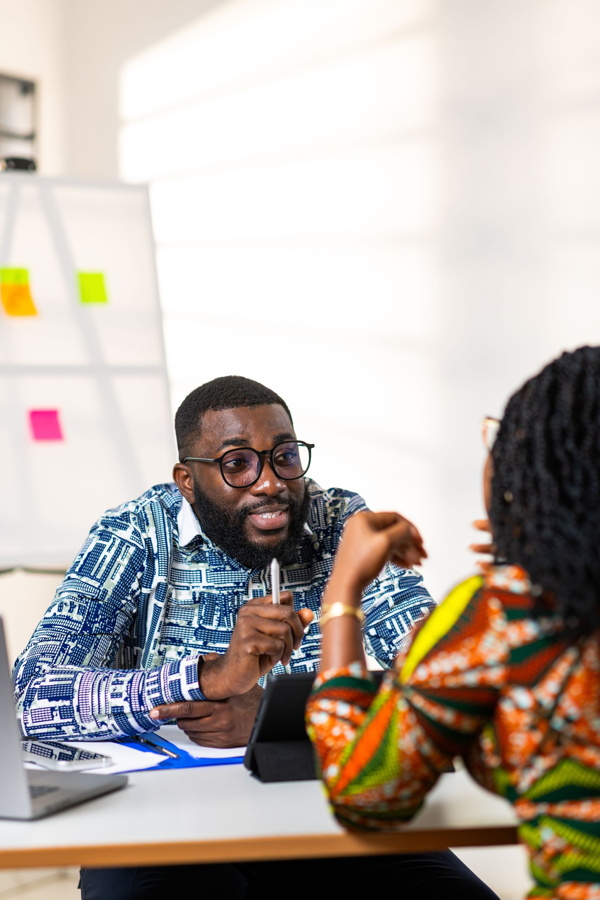 Two African professionals engaging in a lively discussion at a modern office, exuding collaboration and positive energy